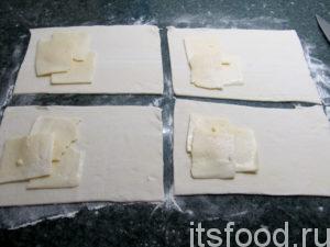 В качестве начинки для слоённого теста, положите на каждый прямоугольник кусочек сыра.