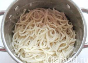 Спагетти отварить так, как написано на упаковке, откинуть на дуршлаг и слегка промыть. Затем смазать сливочным маслом и порционно разложить по тарелкам.