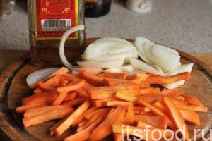 Вегетарианский плов готовится в казане, жаровне или в сковороде «вок». Лучший материал для посуды – это чугун. Поставим большую сковородку вок на прогрев. Нарежем морковь брусочками, а лук можно нарезать полукольцами.