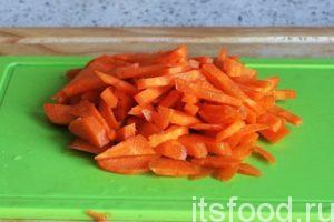 Нарежем морковь крупной соломкой и добавим ее в сковородку. Убавляем огонь.