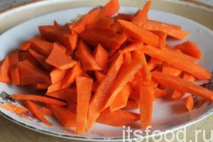 Нарежем морковь крупной соломкой и поместим ее в казан, где происходит обжарка баранины. Все перемешаем. 
