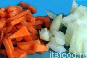 Нарежем промытую морковь на мелкую соломку и добавим ее в кастрюлю. Очищенный лук нужно порезать на мелкие дольки. Отправляем лук вслед за морковью в кастрюлю с рыбным бульоном. 