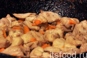 Нальем в глубокую сковородку растительное масло, нагреем его на среднем огне и начнем обжаривать кусочки моркови. Через 3-5 минут добавляем в сковородку маринованную курятину и тушим курицу с морковью еще 5 минут. 