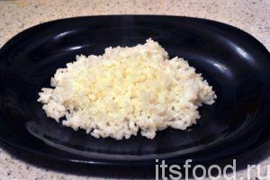 Выкладываем на плоские тарелки рассыпчатый белый рис, который желательно сбрызнуть соевым соусом.